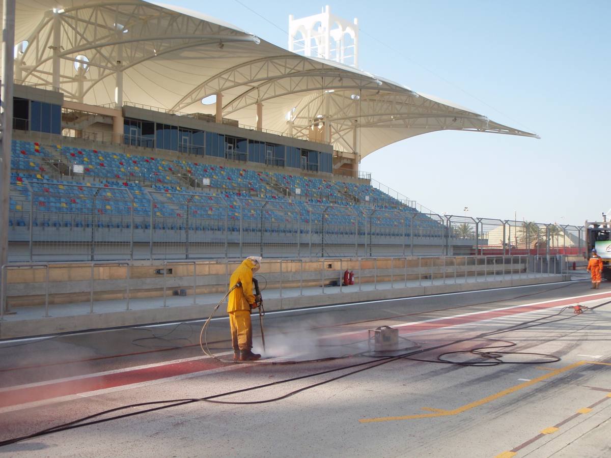 Operators UHP water jetting a large paved surface