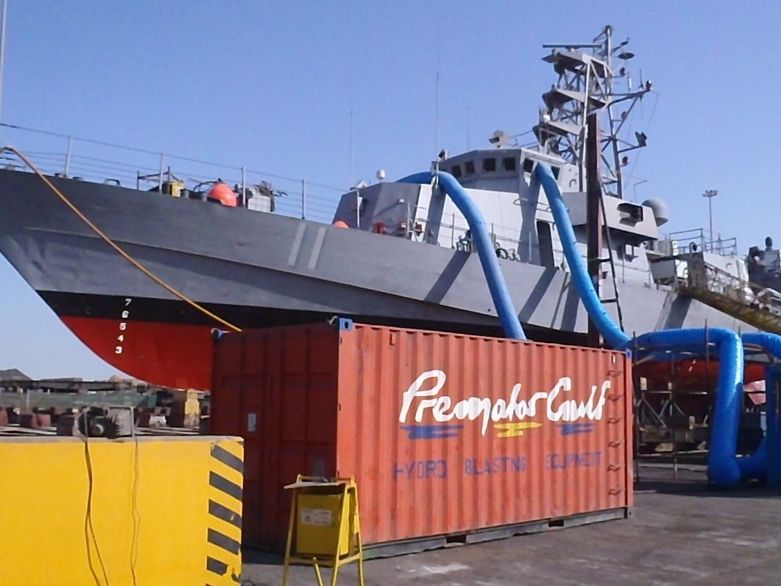 Premator Gulf hydro blasting equipment beside a naval patrol vessel in dry dock